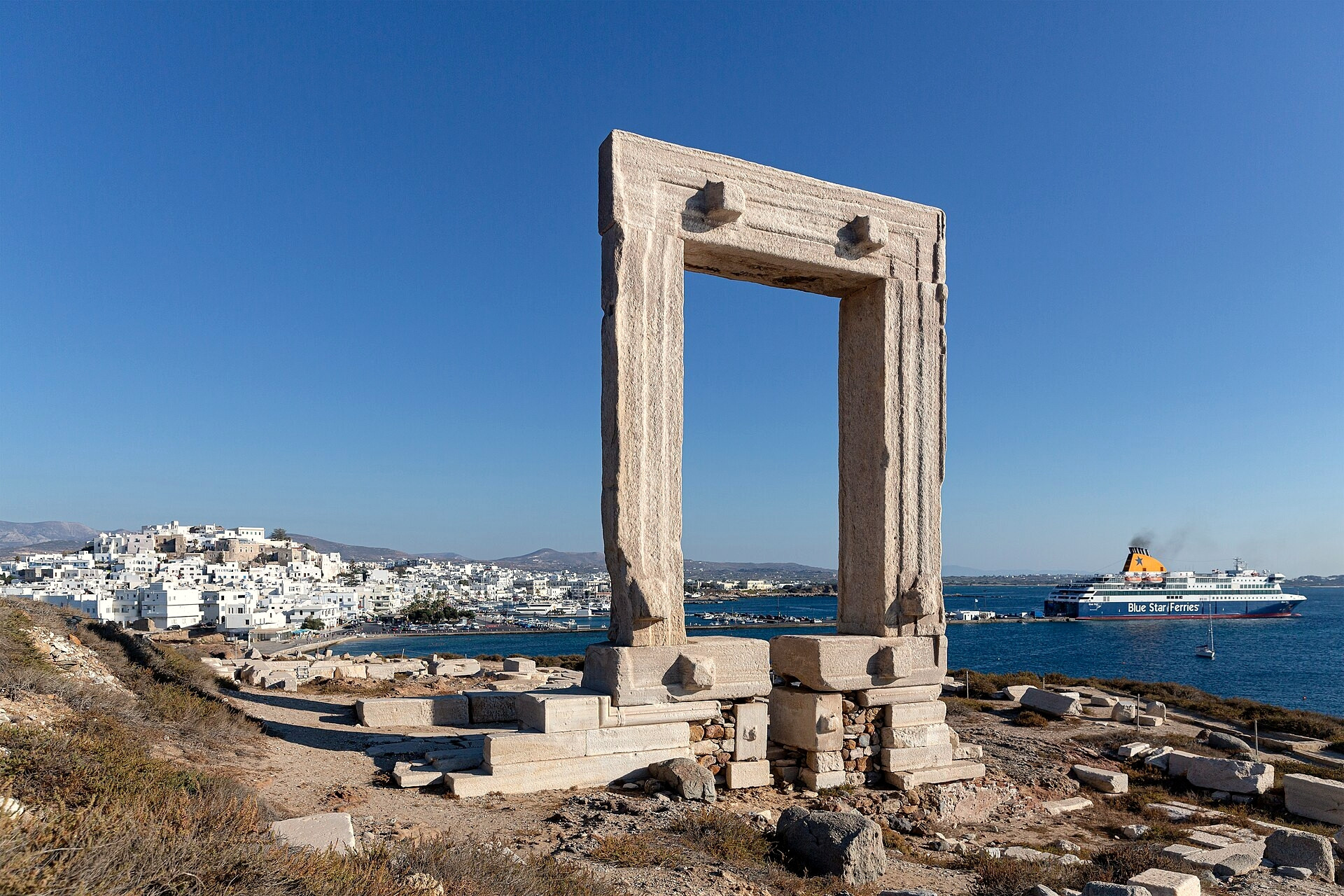 © Manfred Werner, Wikimedia Commons (CC BY-SA 4.0) Veerboot die langs de Portara van Naxos vaart - Naxos, Cycladen - Griekenland © Manfred Werner / Wikimedia (CC BY-SA 4.0)