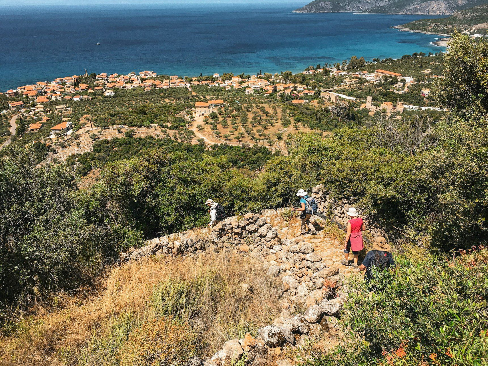 Randonneurs sur un sentier de pierre face à la mer - Péloponnèse - Grèce