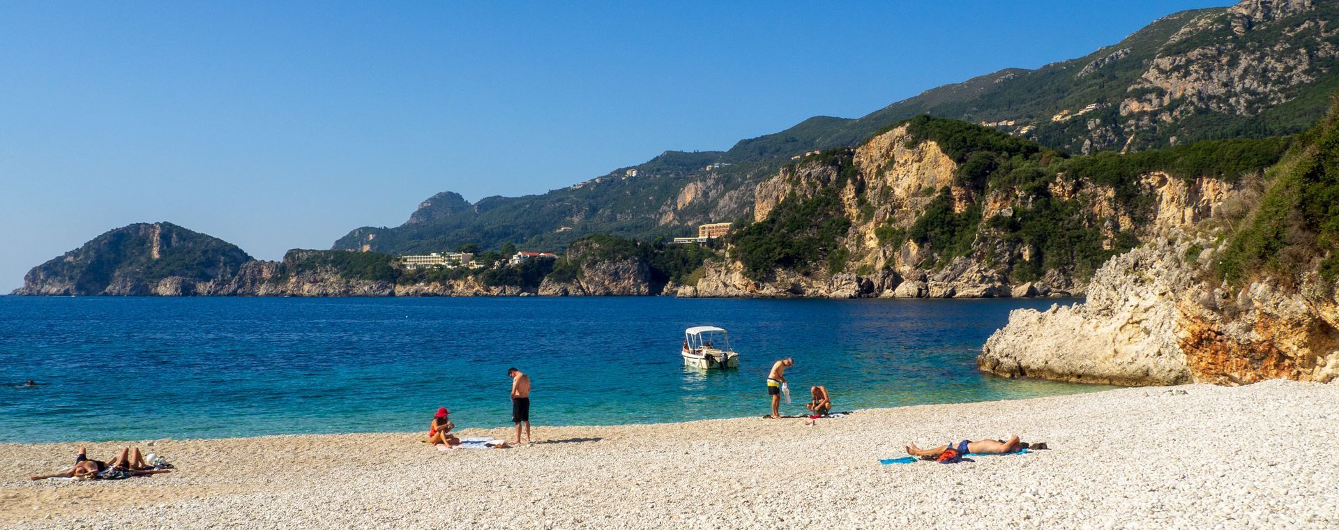 Baigneurs sur la plage de galets de Rovinia - Corfou - Grèce