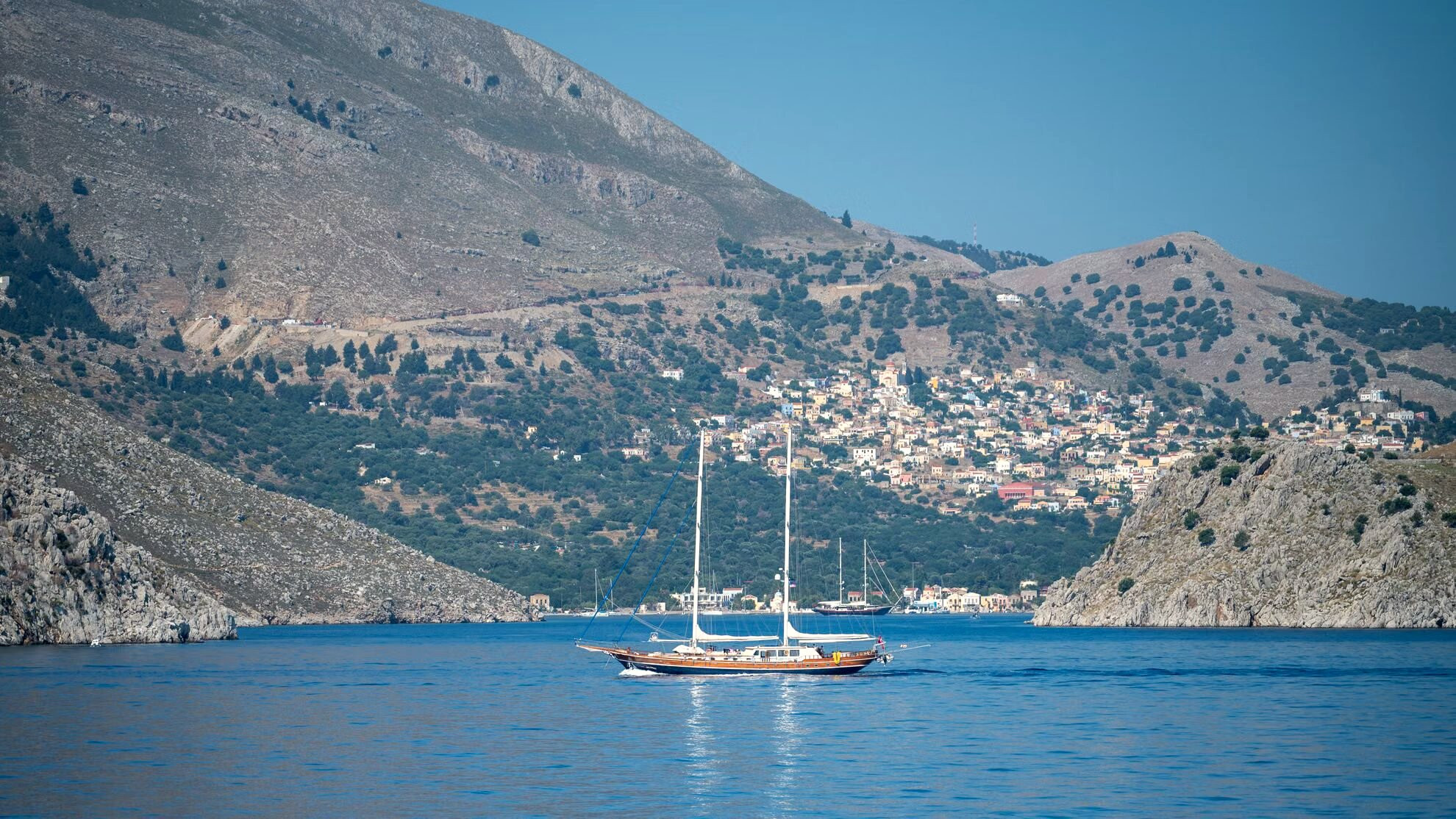 Zeilboot voor anker in een baai aan de voet van de kliffen - Symi - Griekenland
