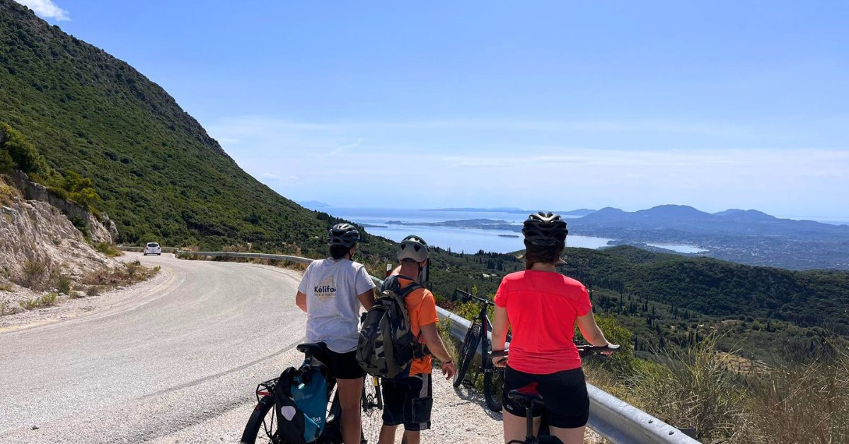 Fietsers met uitzicht over een turquoise baai - Corfu - Griekenland